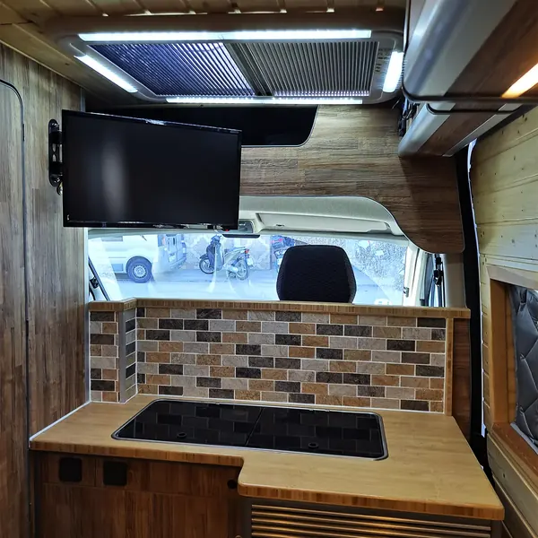 Cocina de una Peugeot Boxer camperizada con azulejo y televisión