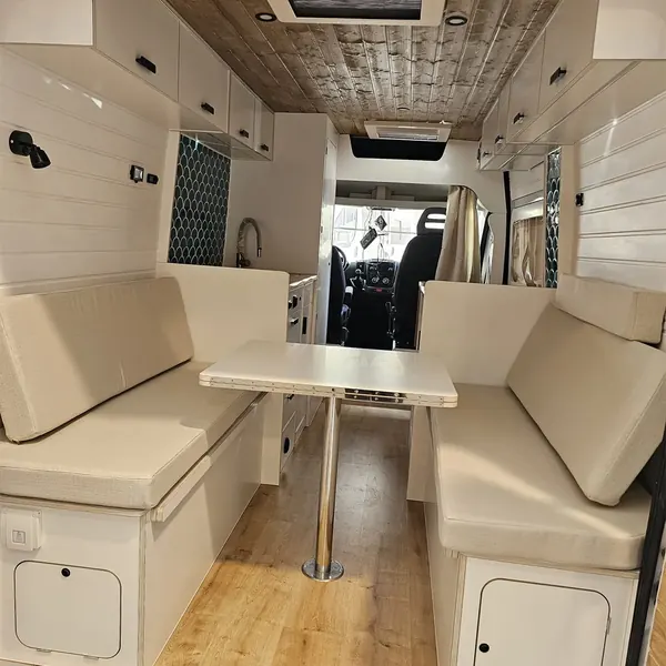 Dinette de camper con dos bancos tapizados y mesa central