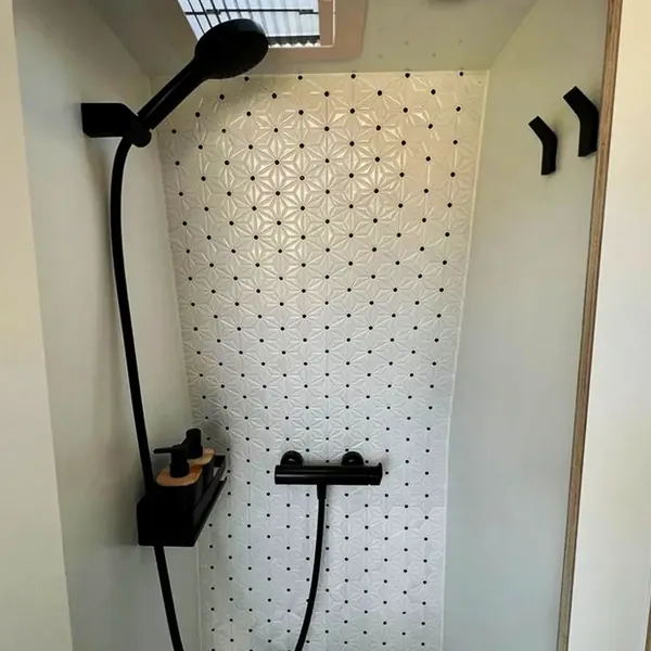 Ducha de camper con azulejo blanco y grifería negra
