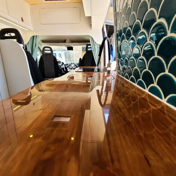 Encimera de madera barnizada de una camper vista desde la cabina