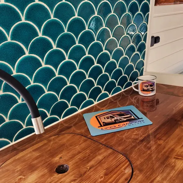 Encimera de madera barnizada con azulejo verde y taza de Lifes Campers
