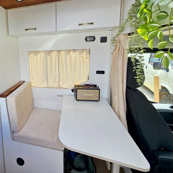 Dinette con mesa y cortinas en una Iveco Daily camperizada