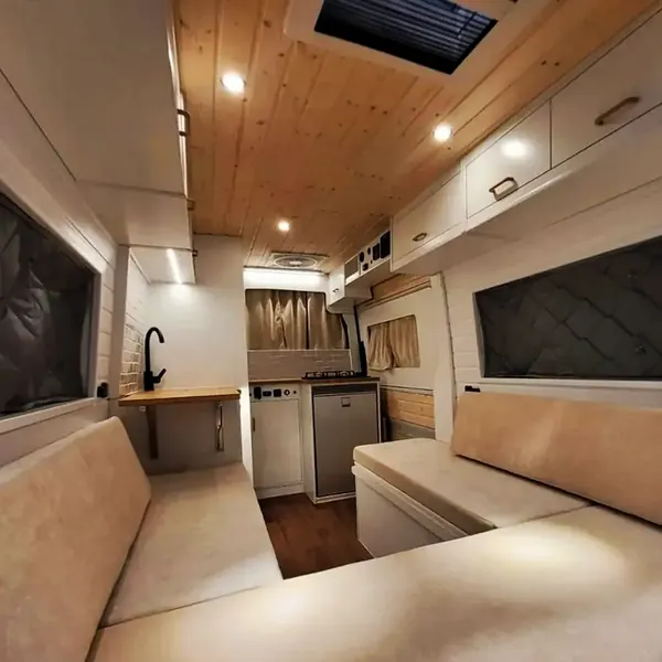Salón de camper con sofá, claraboya y luces en el techo